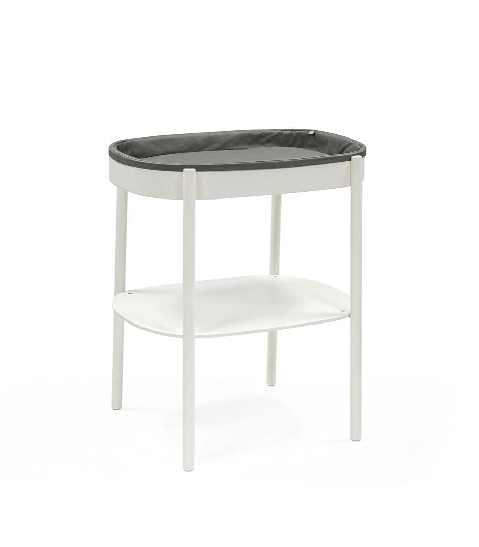 Stokke Sleepi Changing Table – sleek wooden diaper changing station with open storage shelves and soft curved edges for modern nurseries.